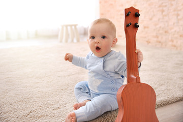 Baby boy playing with toy guitar