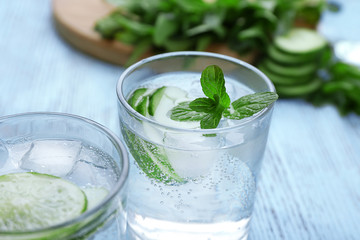 Infused lime water with cucumber on wooden background