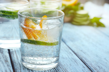 Infused lime water with orange on wooden background