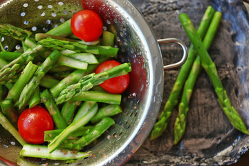 Asparagus with tomatoes in colander
