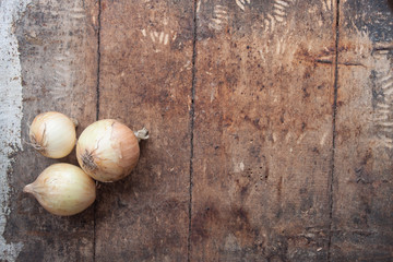 Ripe onions on a wooden background,top view