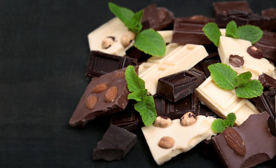 Chocolate pieces with mint leaves on black background