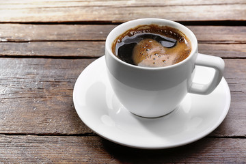 Cup of fresh coffee on wooden background