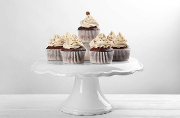 Tasty cupcakes on light background