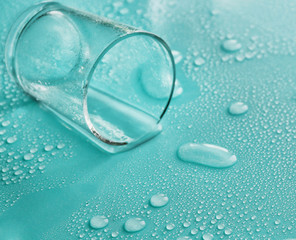 Overturned shot glass on turquoise background