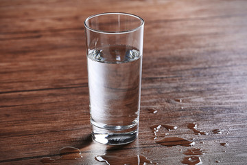Filled glass of water on wooden background