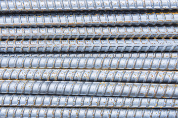 The deform bar, the steel deform bar pile on the construction site. Close-up the corrosion on the steel deform bar which cause of rust.