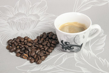 cup of coffee and beans arranged in a heart