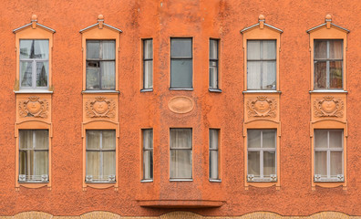Fototapeta na wymiar Several windows in a row and bay window on facade of urban apartment building front view, St. Petersburg, Russia.
