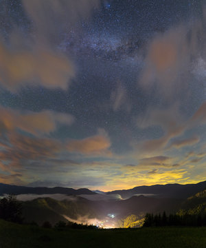Milky way over a mountain valley and village