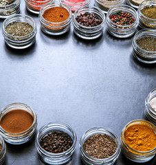 Spices on black background in special jars. Food