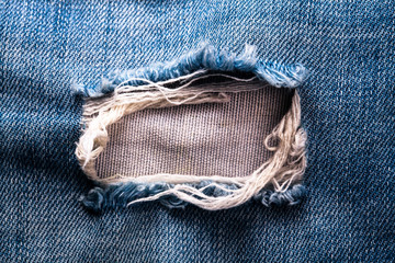 blue jean texture with a hole and threads showing