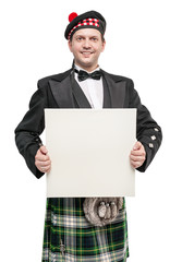 Scottish man in traditional national costume with empty banner