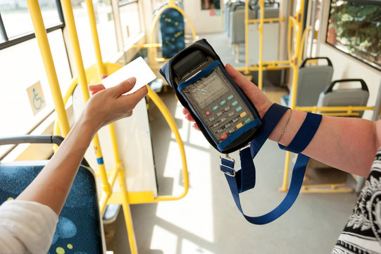 Human hand holding plastic cards. Passenger pays for fare in public transport. Payment terminal, credit card reader, sales concept.