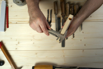 Cropped image of senior carpenter measuring wood in workshop
