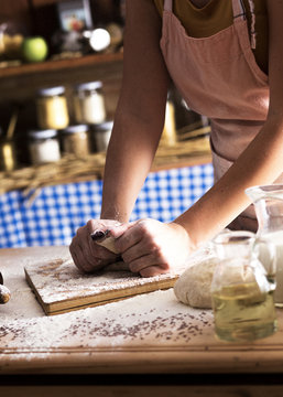 Close up of female baker hands kneading dough and making bread.