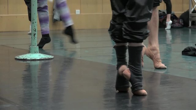 Feet of classical ballet dancers in the workout.