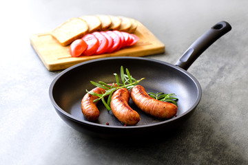 Sausages frying in a pan