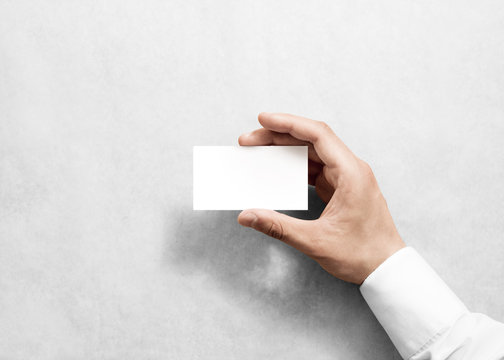 Hand holding blank white business card design mockup. Clear calling card mock up template holding arm. Visit pasteboard paper surface display front. Standart offset card print. Business card branding