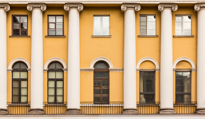 Several windows and columns in a row on facade of urban apartment building front view, St. Petersburg, Russia.