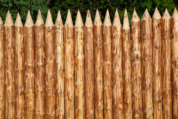 A stockade of logs. A fence made of natural logs, fence in ancient style.