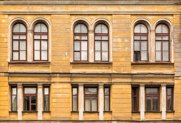 Several windows in a row on facade of urban apartment building front view, St. Petersburg, Russia.