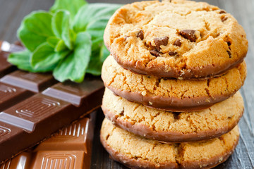Chocolate cookies stacked vertical with milk and dark chocolate bar
