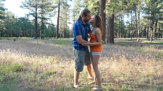 A man kisses his girl, then picks her up