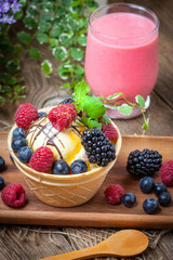 Tasty ice cream dessert with fruit in a waffle bowl.