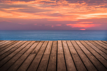 Fototapeta na wymiar perspective empty wooden terrace with sunset on sea background