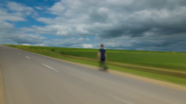 4 in 1! The man walk along the road against the background of cloud stream. Time lapse