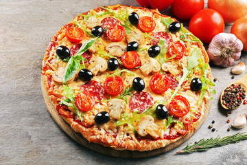 Delicious tasty pizza with ingredients on wooden table