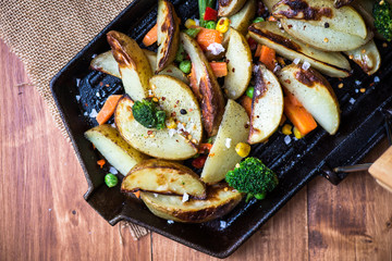 Potato Wedges with Vegetables on Iron Cast Pan