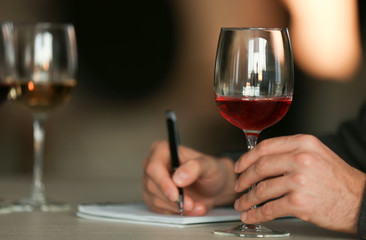 Man tasting new sorts of wine at the table