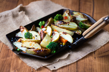 Potato Wedges with Vegetables on Iron Cast Pan