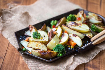 Potato Wedges with Vegetables on Iron Cast Pan