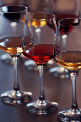 Many glasses of different wine in a row on a table