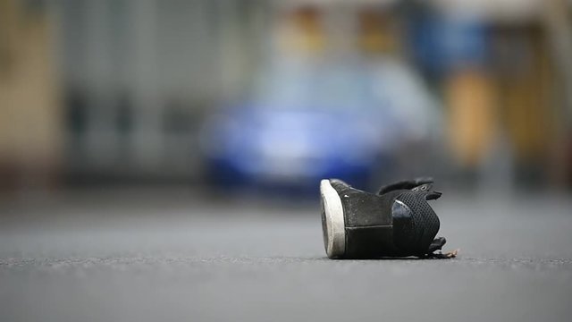 Shoe on the street with cars in background after victim was hit by vehicle