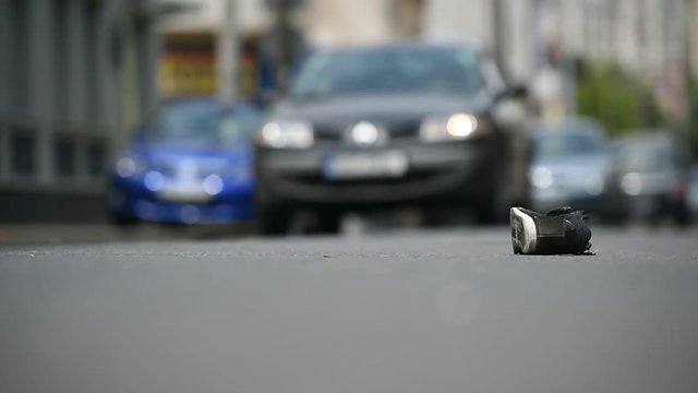 Shoe on the street with cars in background after victim was hit by vehicle