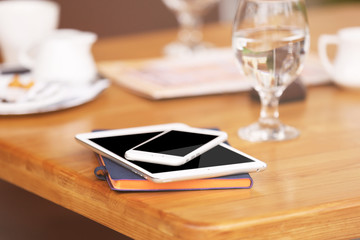 Gadgets on wooden table in cafe