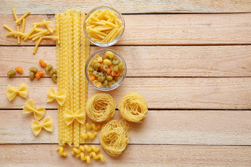 Different types of pasta on wooden table background