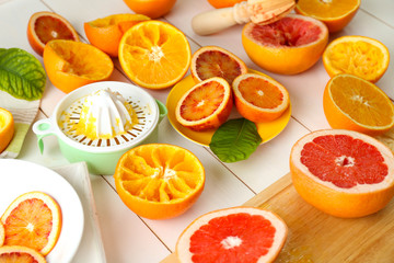 Juicing delicious oranges on white wooden table