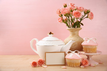 Mother Day concept. Roses with cupcake on pink background