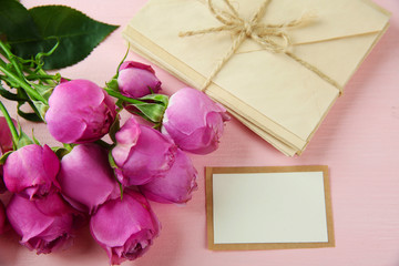 Fresh roses and present on wooden background