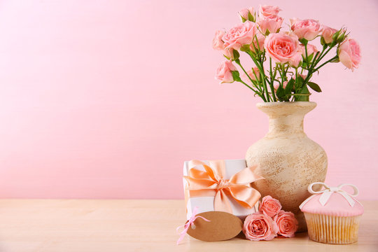 Mother Day concept. Roses with cupcake on pink background