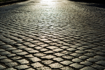 sunlight on cobblestone road. old stone texture