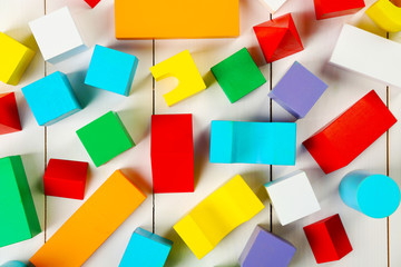 Fototapeta na wymiar Colorful wooden children's building blocks on white wooden background