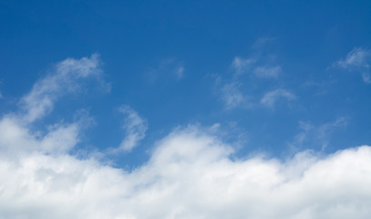 Naklejka na ściany i meble White clouds in the blue sky. Cloudscape over horizon.