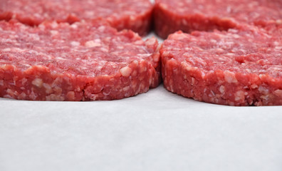Raw meat burgers for hamburgers on parchment