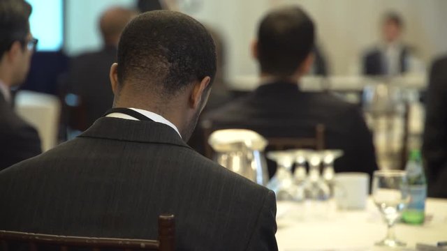 An African American black man attends a lecture